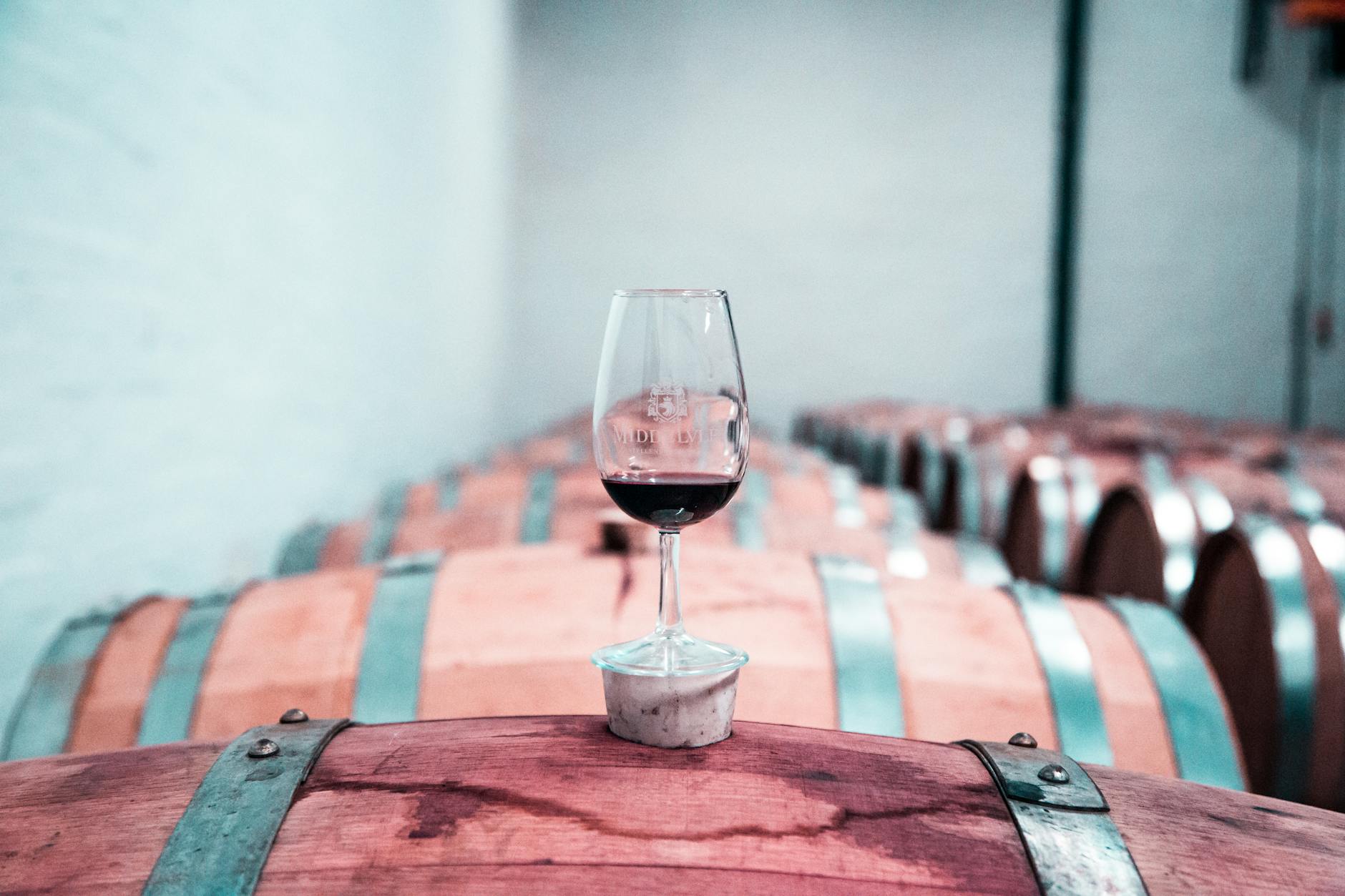 photo of wine glass on top of barrel