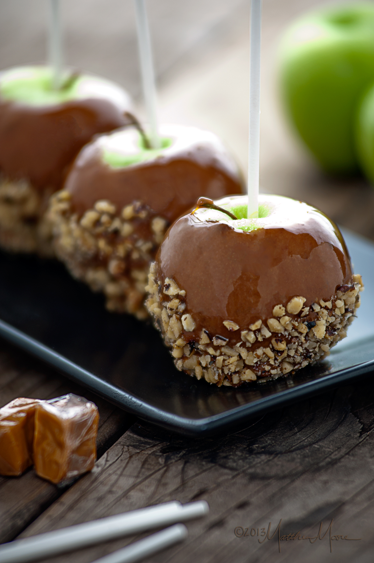 Caramel apples coated with chopped nuts