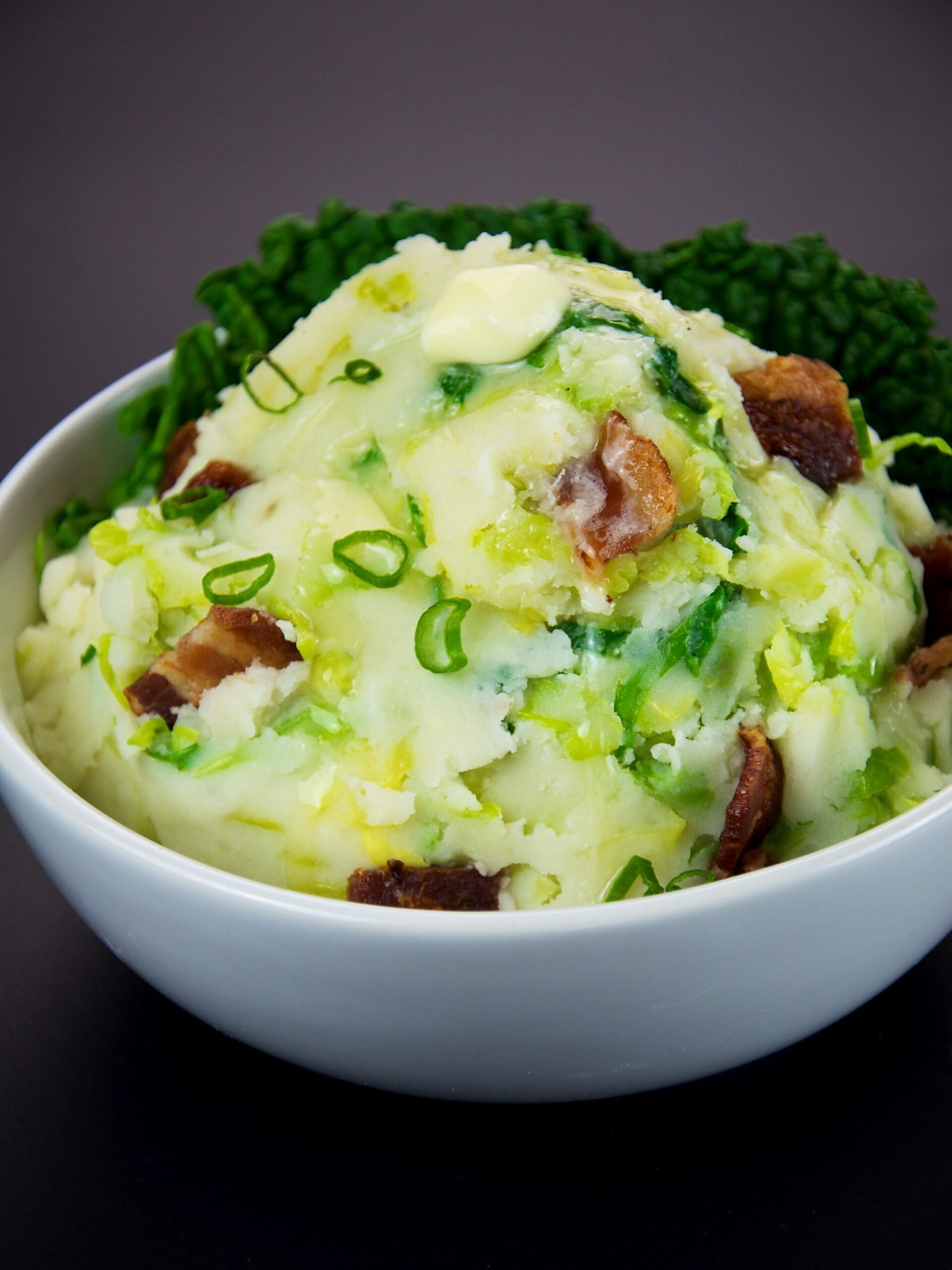 A bowl of colcannon with greens and scallions