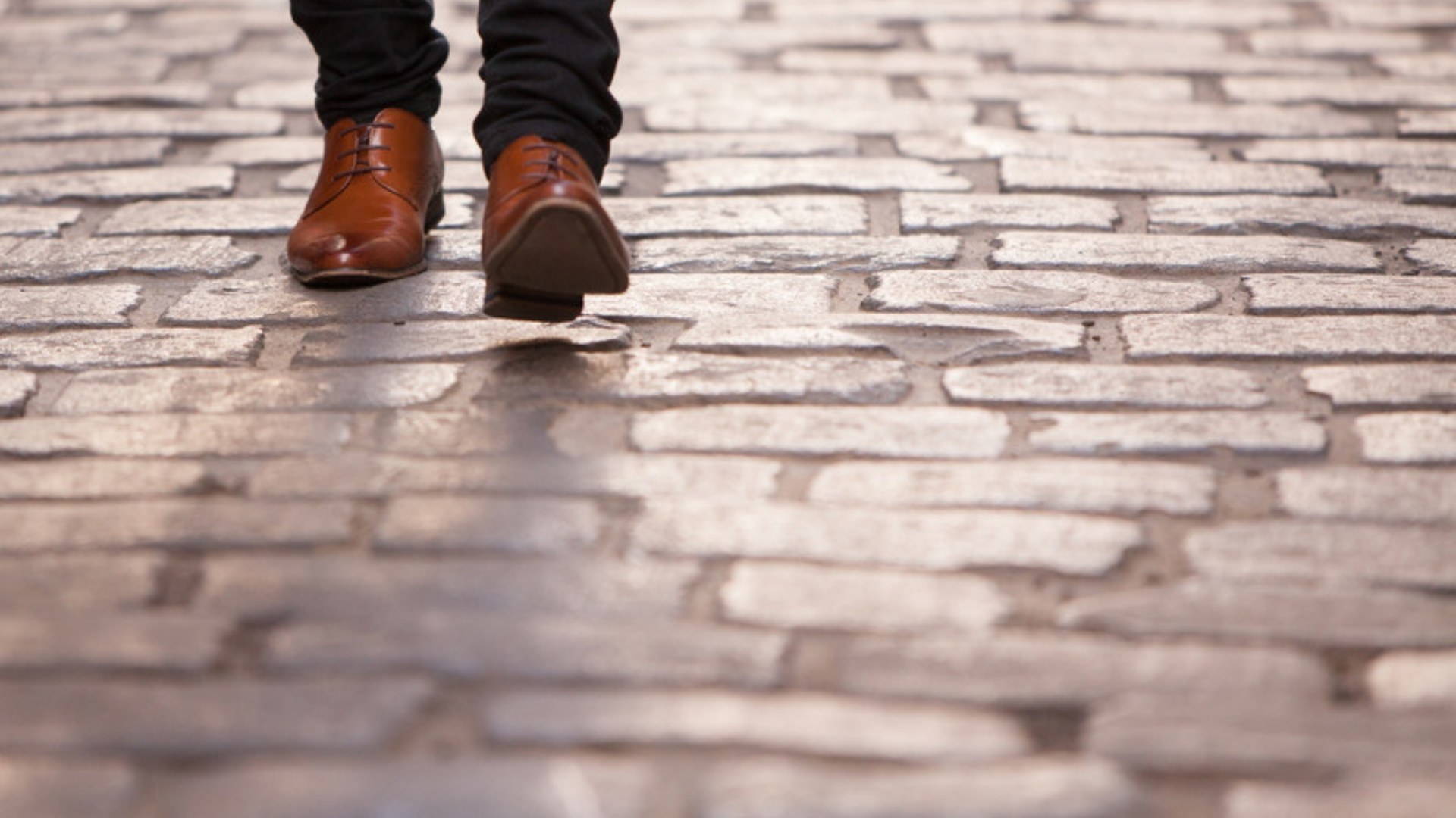 Brown leather shoes on a cobblestone street