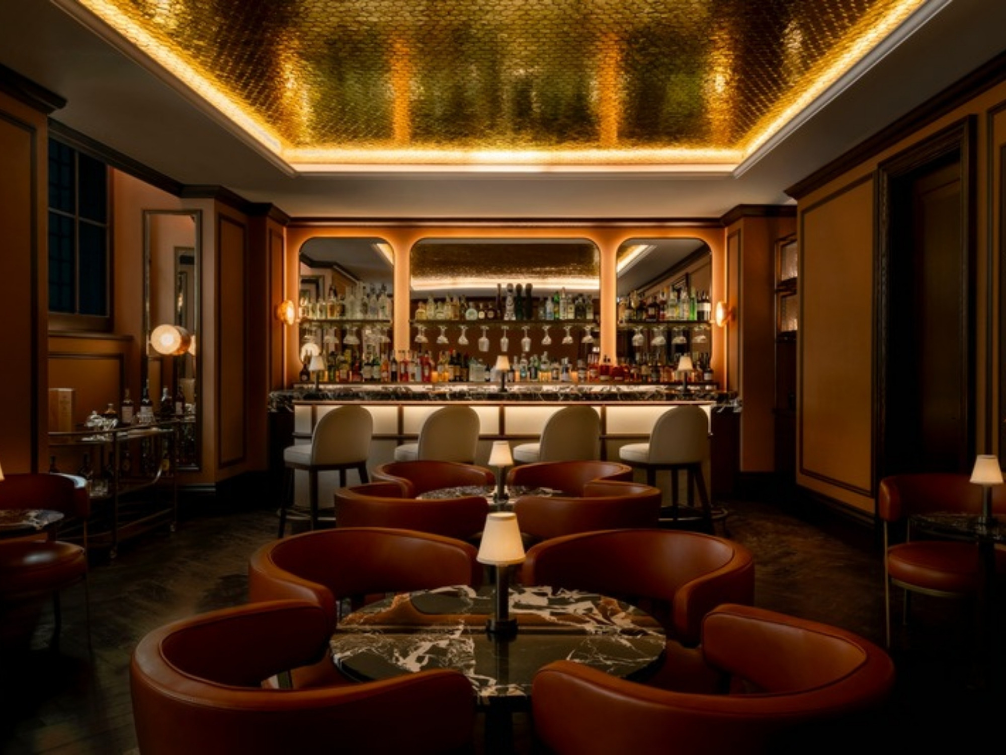 Ocra, the bar at Corinthia Rome, with a gilded ceiling, marble tables and cognac leather armchairs