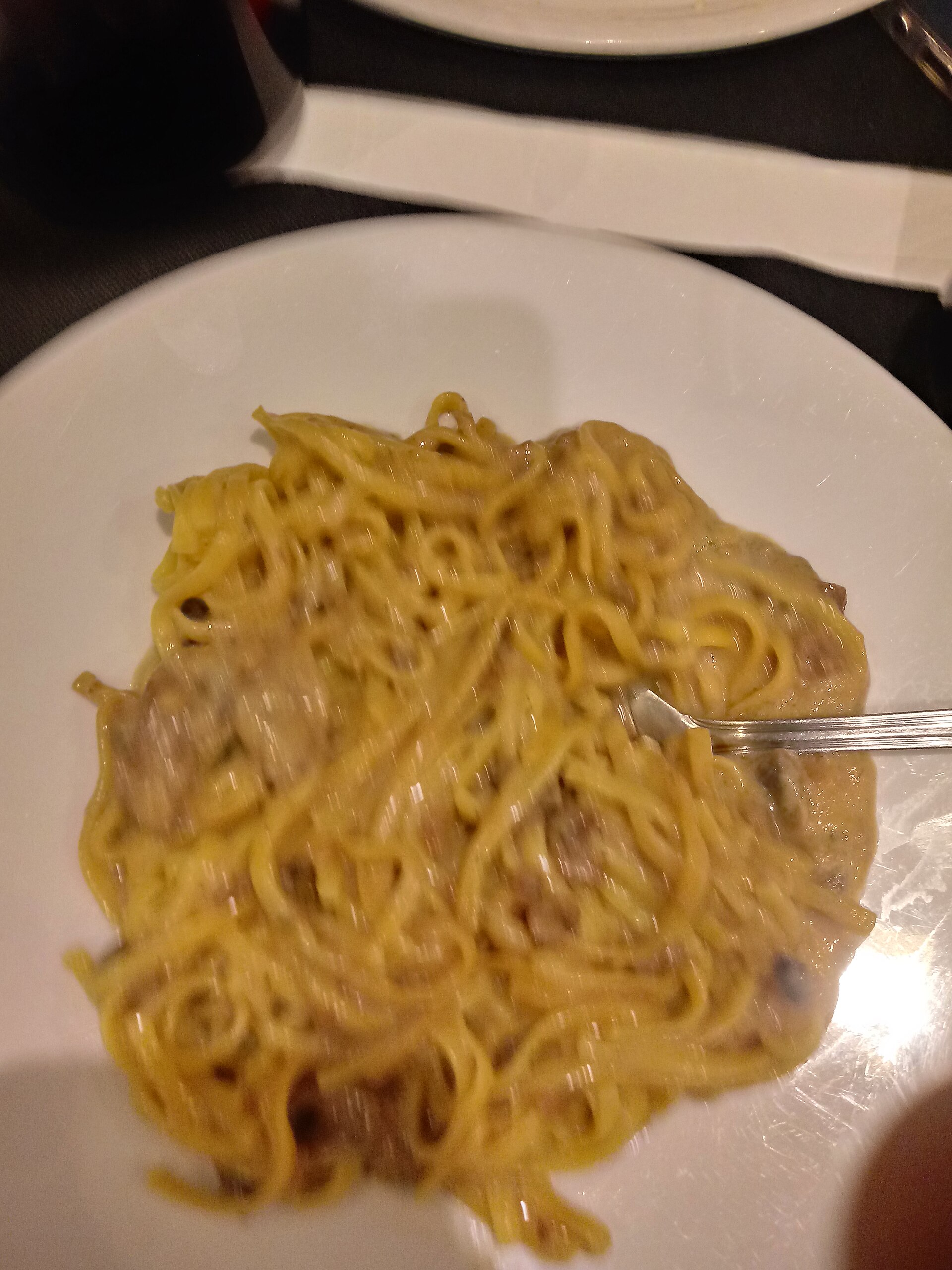 A plate of thin egg pasta with mushrooms